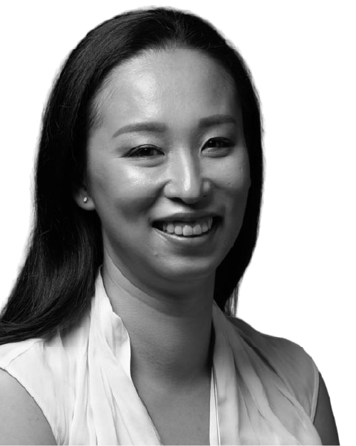 Black and white photo of Cassandra Chiu, she is smiling, has long hair and is wearing a white top